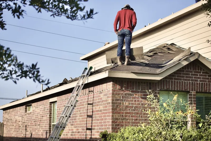 Professional roofer working on a residential roof in Lyons Falls
